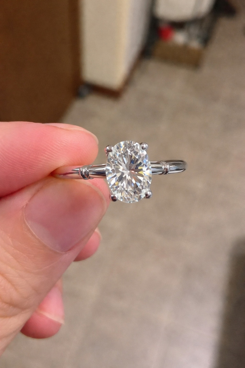woman holding 2ct oval moissanite ring 4 prong solitaire close up hand jewelry photo