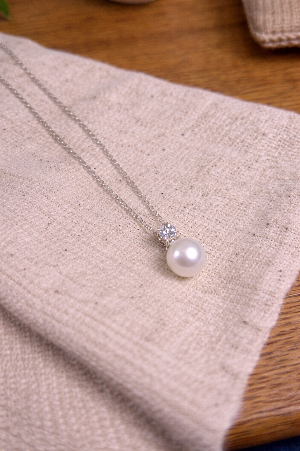 pearl drop necklace with moissanite laid flat elegant jewelry styling flat lay photo